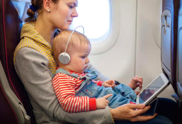 Madre con su bebé e ipad en el avión